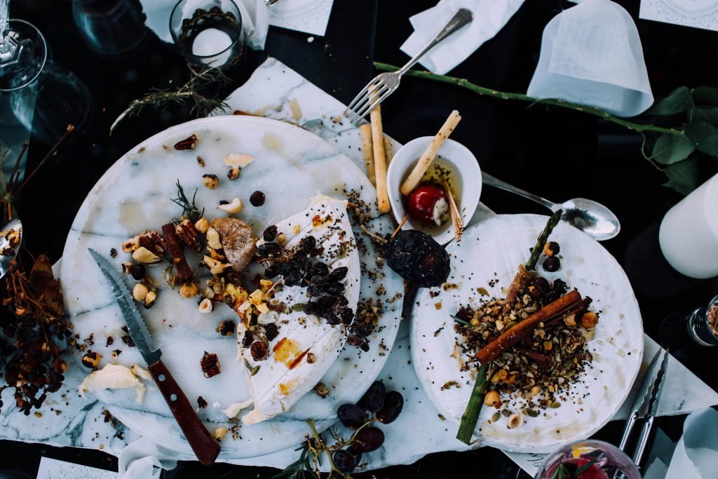 pexels-photo-4997810-4997810 From above of plates with remains of various dishes left after festive dinner on table with cutlery and flowers